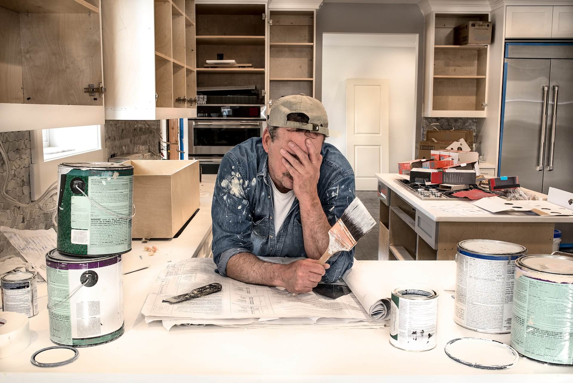 Man exhausted from remodeling mistakes in the kitchen.